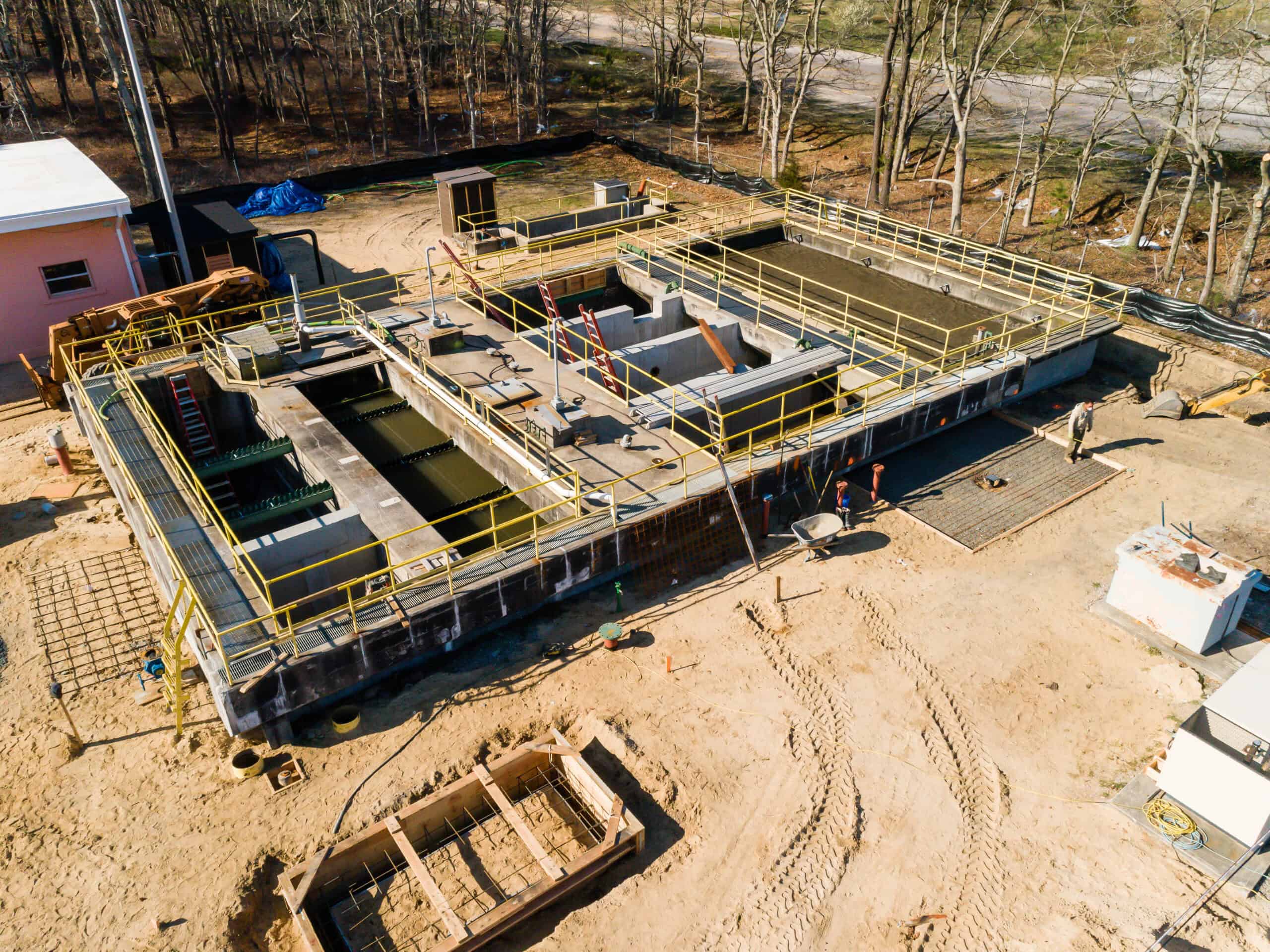 Industrial water treatment facility under construction with metal framework and piping.