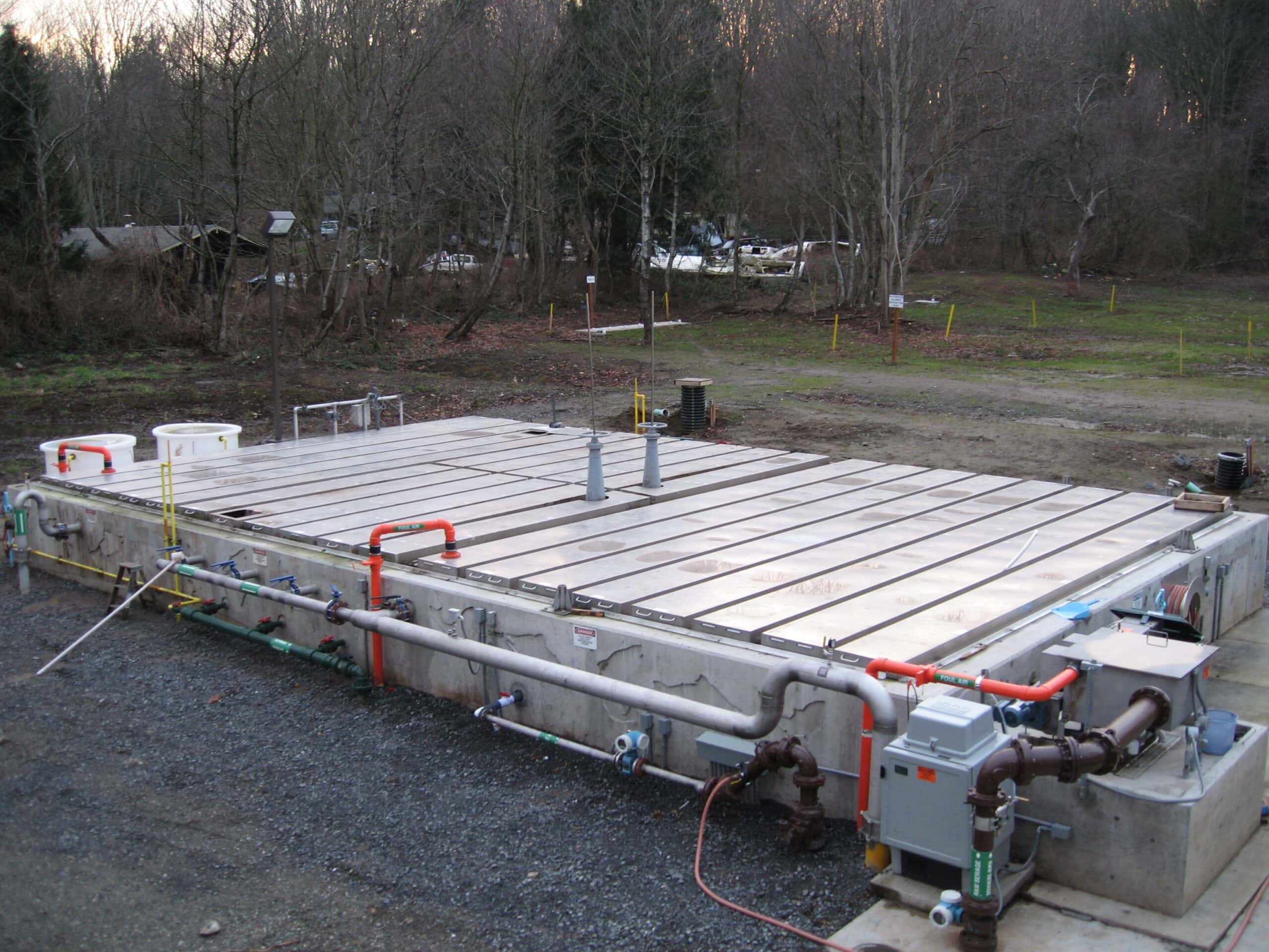 Industrial wastewater treatment tank with piping and control systems.