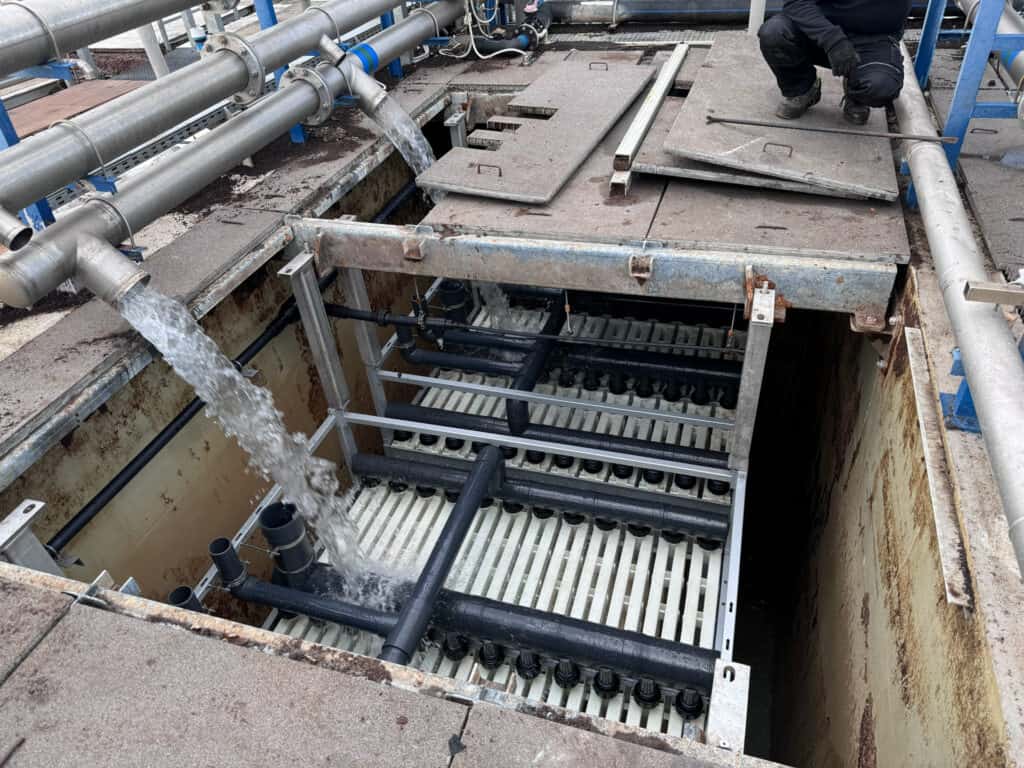 Industrial wastewater treatment system with aeration tanks and piping.