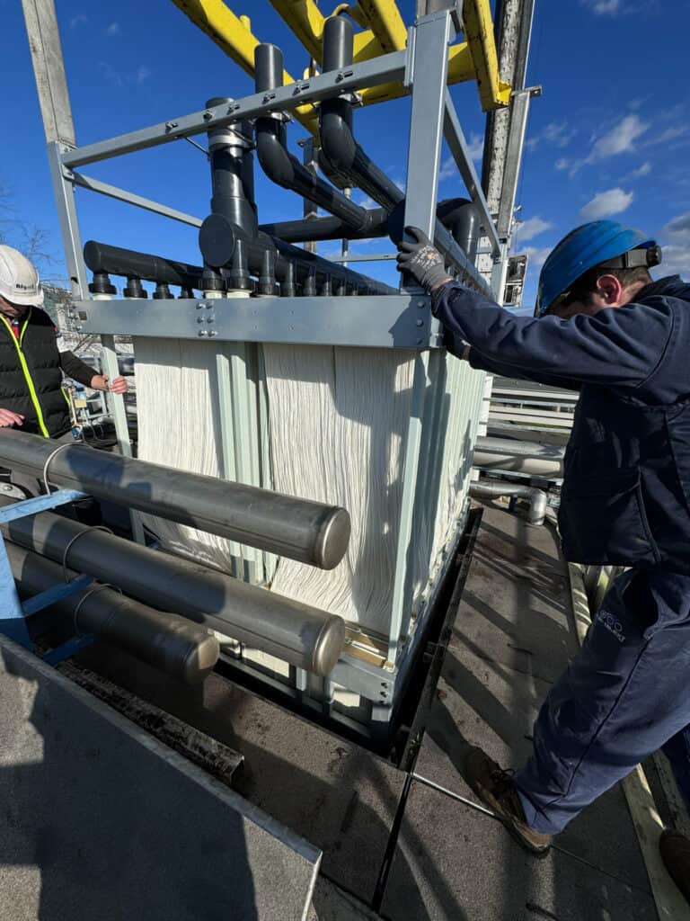 Technicians installing water treatment equipment at a wastewater plant.