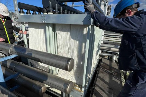 Technicians installing water treatment equipment at a wastewater plant.